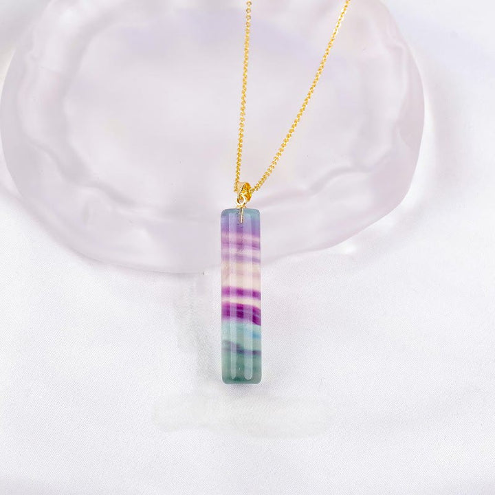 Buddha Stones Pendentif cylindrique de protection en fluorite naturelle colorée - Fluorite naturelle (la couleur, la forme et la taille peuvent varier) - image 1