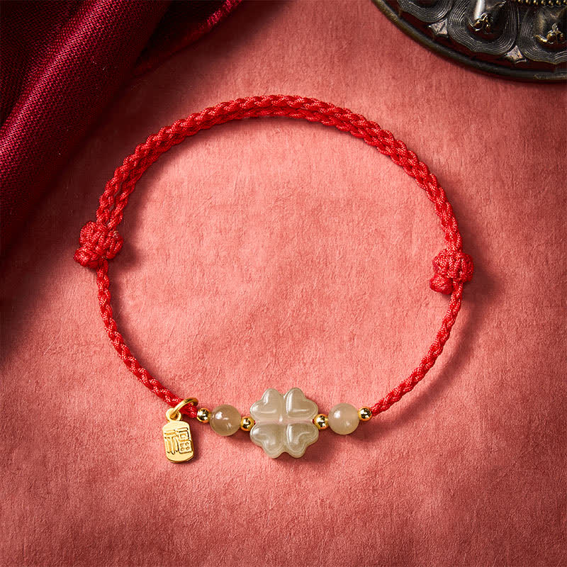 Bracelet porte-bonheur en Buddha Stones , orné d'un trèfle à quatre feuilles et du caractère Fu, avec un cordon rouge. - image 1