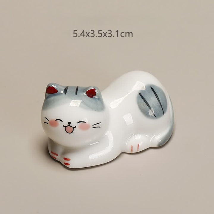 Buddha Stones Petit porte-baguettes de table en céramique en forme de chat porte-bonheur - Chat couché sur le côté gauche. Dimensions approximatives : 5,4 × 3,5 × 3,1 cm - image 1