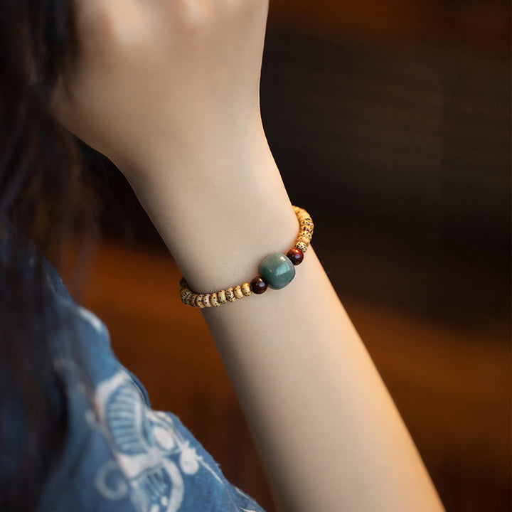 Bracelet de sagesse en bois de santal rouge à petites feuilles et Buddha Stones