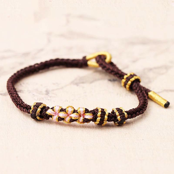Bracelet tressé fait main à huit brins avec trois fleurs de pêcher et Buddha Stones