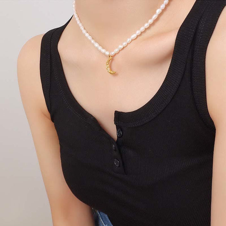 Collier avec pendentif en forme de croissant de lune et de perle