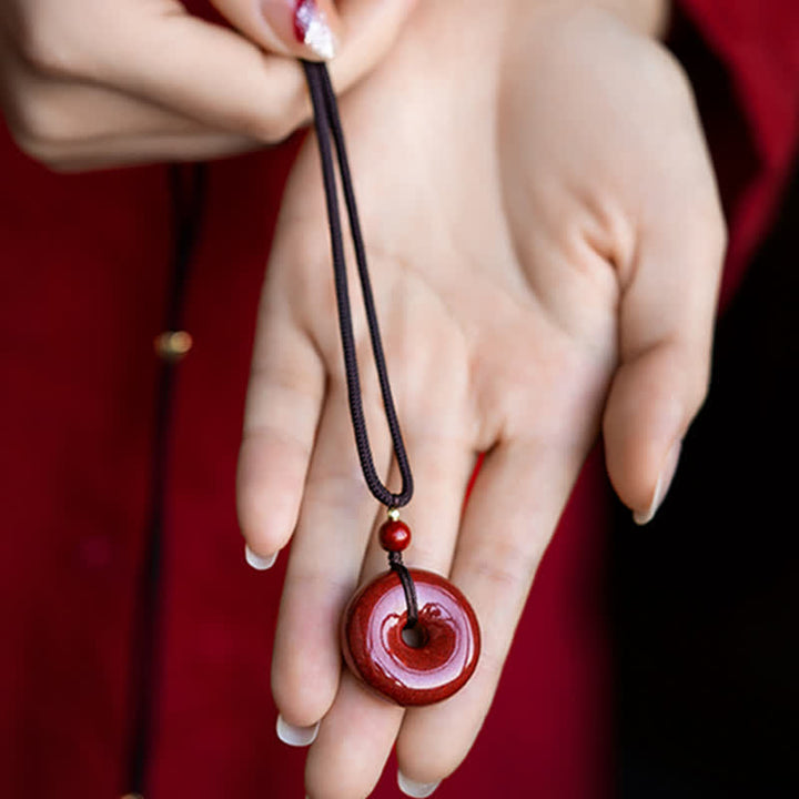 Collier avec pendentif en pierre de cinabre et boucle de paix en Buddha Stones