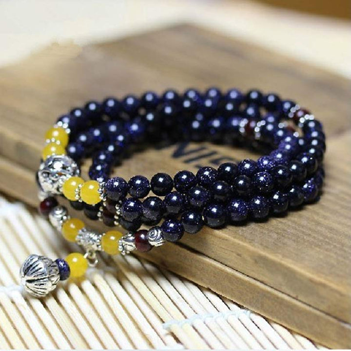 Bracelet Mala en grès bleu avec breloques de richesse et Buddha Stones