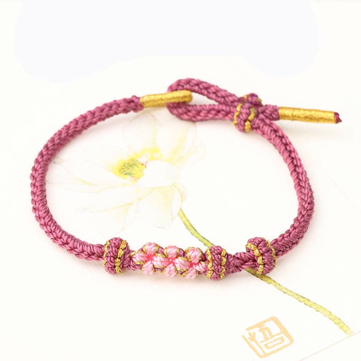 Bracelet tressé fait main à huit brins avec trois fleurs de pêcher et Buddha Stones