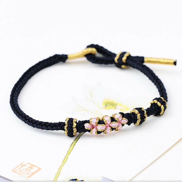 Bracelet tressé fait main à huit brins avec trois fleurs de pêcher et Buddha Stones