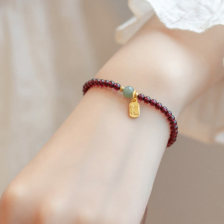 Bracelet porte-bonheur en Buddha Stones, quartz fraise, grenat, jade, caractère Fu