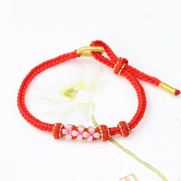 Bracelet tressé fait main à huit brins avec trois fleurs de pêcher et Buddha Stones