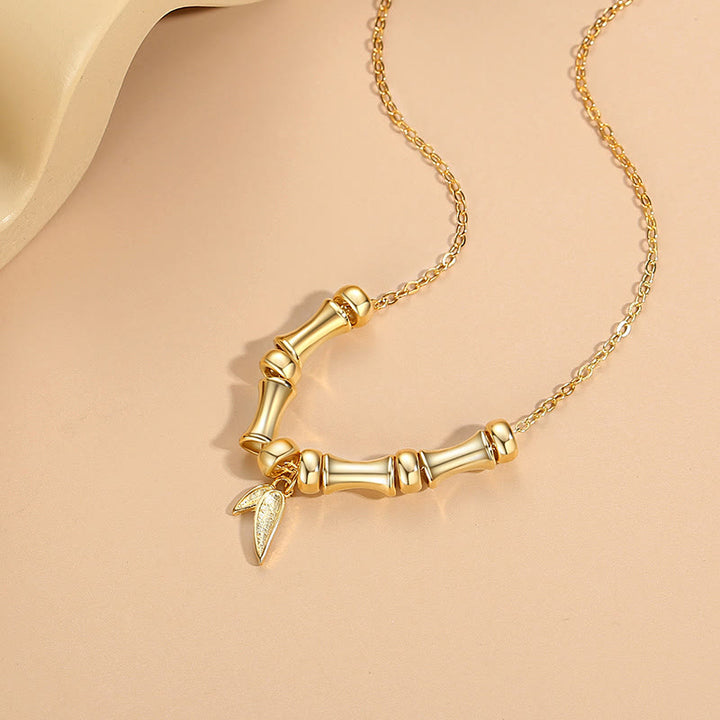 Collier pendentif en acier titane avec motif de bambou doré et Buddha Stones