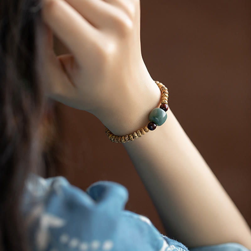 Bracelet de sagesse en bois de santal rouge à petites feuilles et Buddha Stones