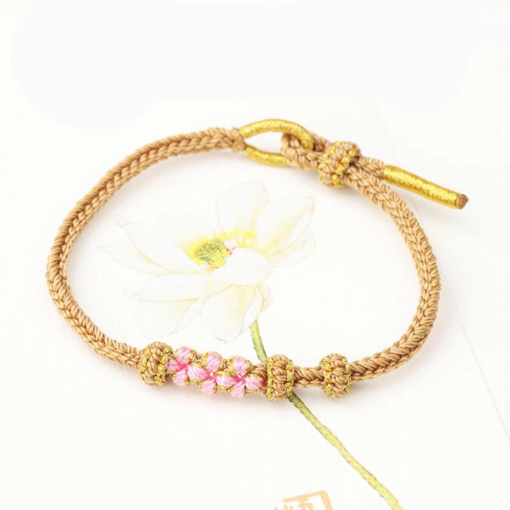 Bracelet tressé fait main à huit brins avec trois fleurs de pêcher et Buddha Stones