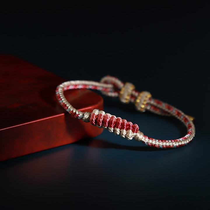 Bracelet de protection tressé à huit fils en Buddha Stones tibétain fait à la main avec roue de prière et nœud de paix