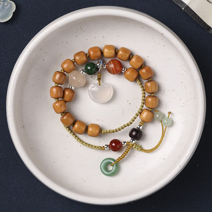 Bracelet double tour apaisant avec breloque en forme de boucle de paix et de bois de santal vert et calcédoine de Buddha Stones