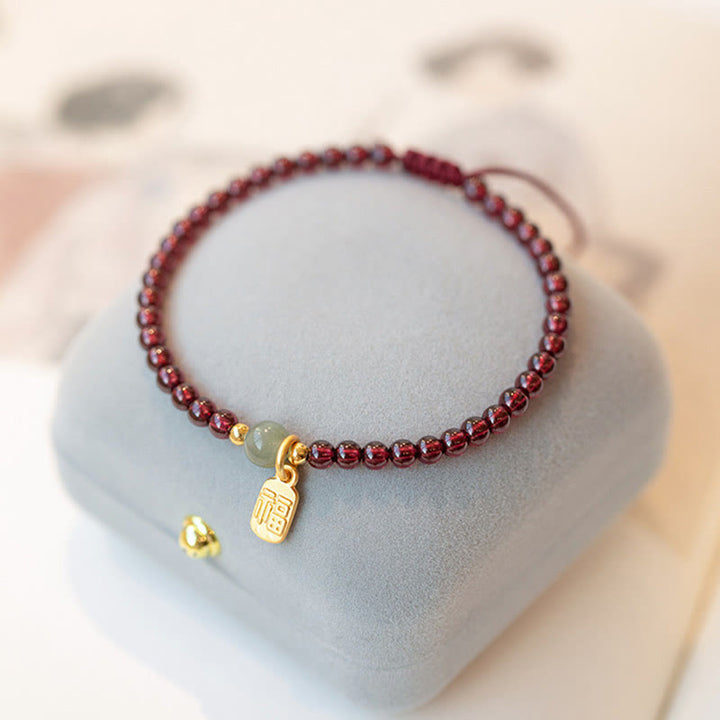 Bracelet porte-bonheur en Buddha Stones, quartz fraise, grenat, jade, caractère Fu