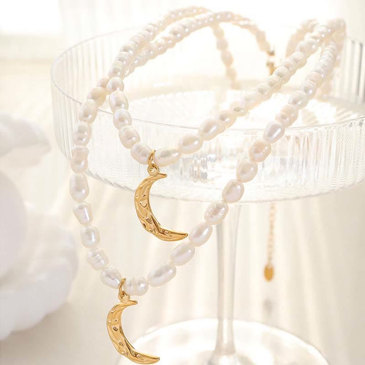 Collier avec pendentif en forme de croissant de lune et de perle