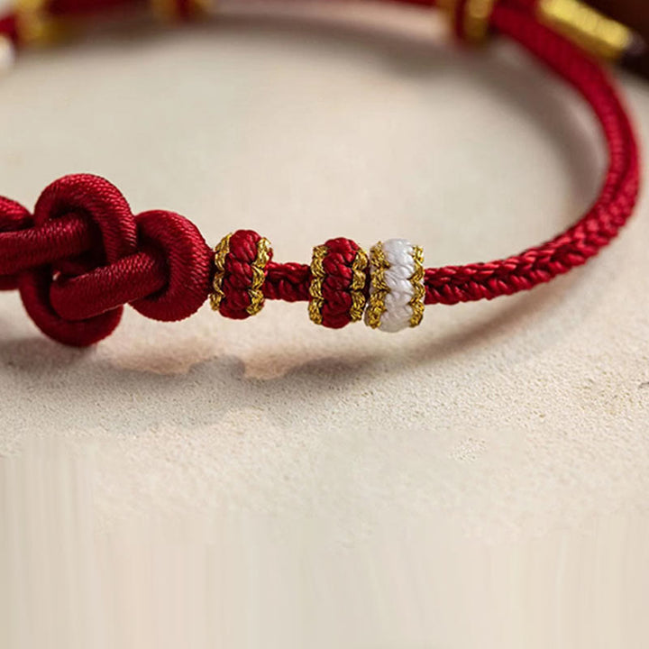 Bracelet porte-bonheur en corde avec breloque en fleur de pêcher et nœud d'amour véritable fait à la main par Buddha Stones