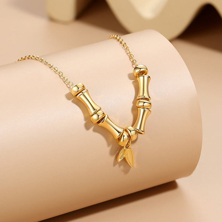 Collier pendentif en acier titane avec motif de bambou doré et Buddha Stones