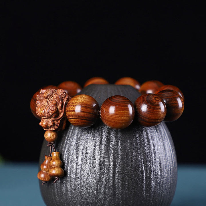 Bracelet de protection sculpté en forme de dragon en bois de santal vert et bois de rose avec petites feuilles de Buddha Stones