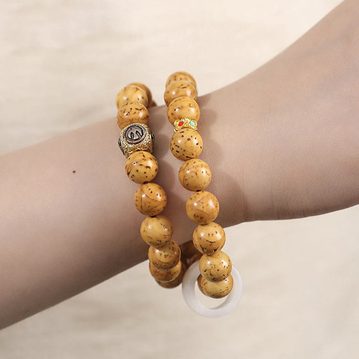 Bracelet double tour en Buddha Stones tibétaines naturelles violettes et dorées avec graines de Bodhi et de richesse