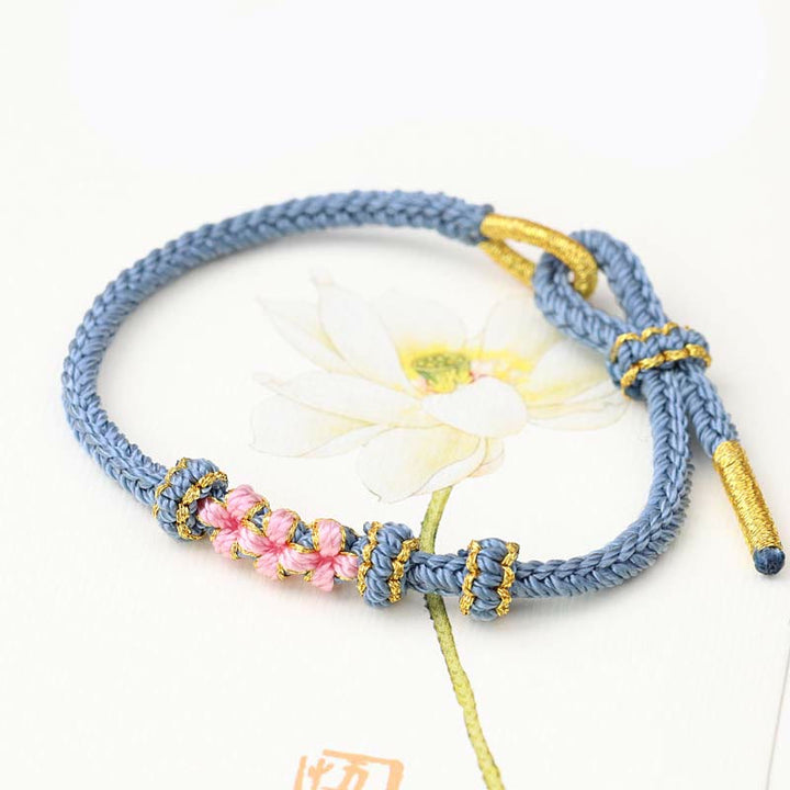 Bracelet tressé fait main à huit brins avec trois fleurs de pêcher et Buddha Stones