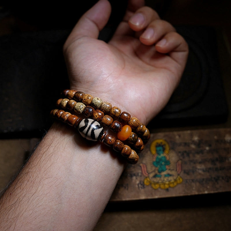 Bracelet triple tour en perles d'ambre et dzi tibétaines en Buddha Stones et graines de Bodhi, perles d'agate et de déesse de la richesse Zakiram
