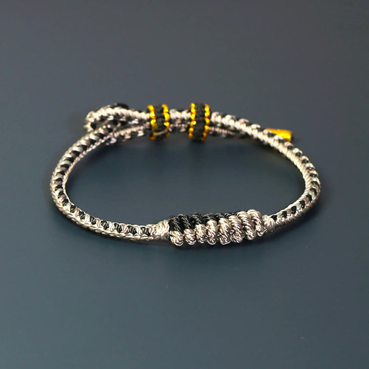 Bracelet de protection tressé à huit fils en Buddha Stones tibétain fait à la main avec roue de prière et nœud de paix