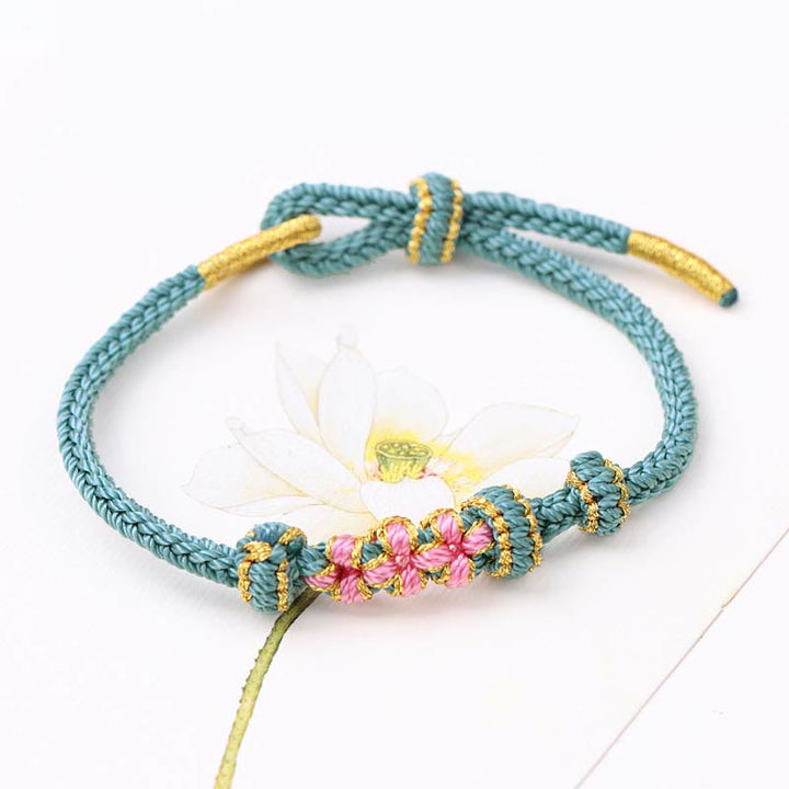 Bracelet tressé fait main à huit brins avec trois fleurs de pêcher et Buddha Stones