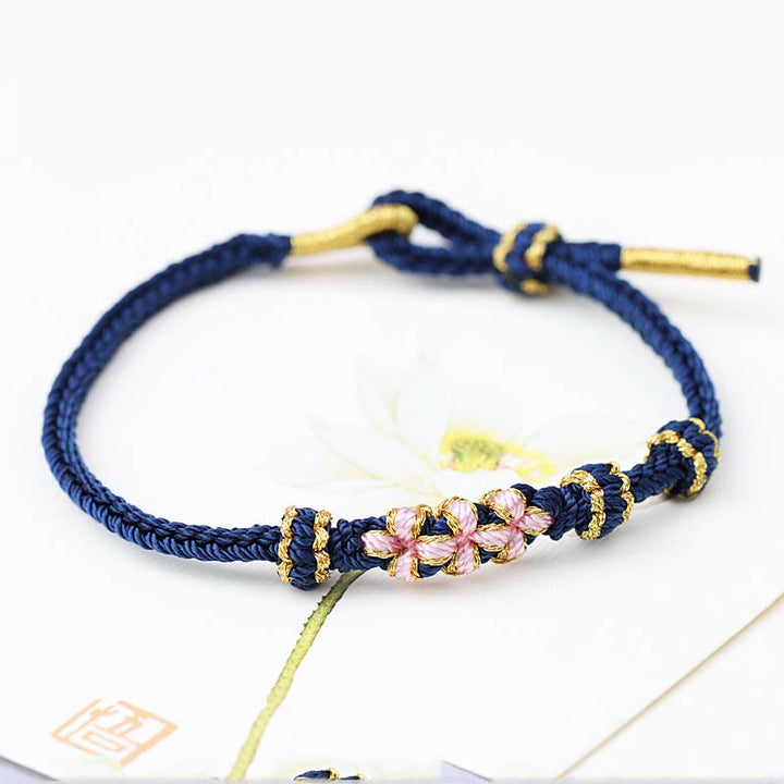 Bracelet tressé fait main à huit brins avec trois fleurs de pêcher et Buddha Stones