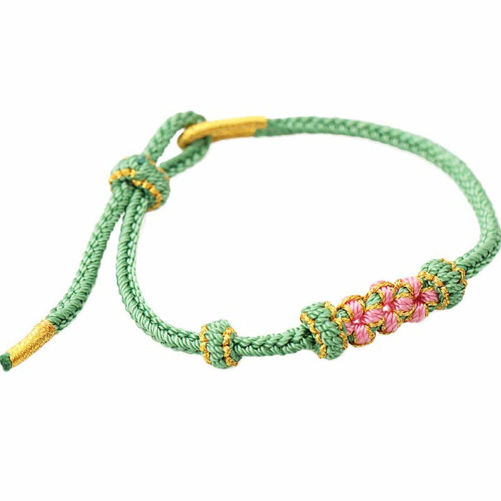Bracelet tressé fait main à huit brins avec trois fleurs de pêcher et Buddha Stones